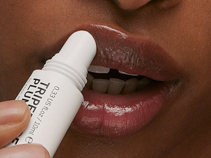 Model applying lip balm to lips