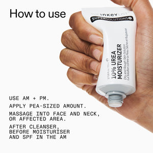 Hand holding 10% Urea Moisturiser with usage instructions on a white background