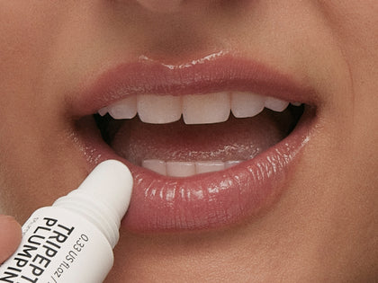 Model applying lip balm to lips