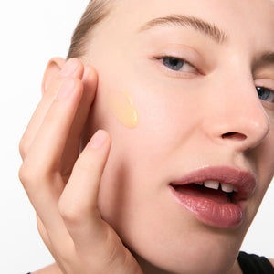Model applying Retinol Serum to her face