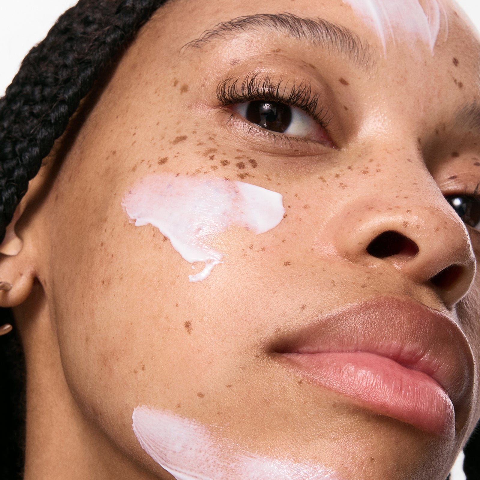 Close-up of a person's face with Dewy Sunscreen SPF 30 on their cheek