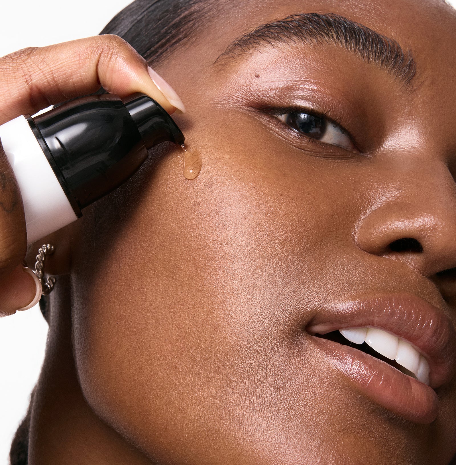 Person applying 15% Vitamin C + EGF Serum to face with close-up focus on skin texture