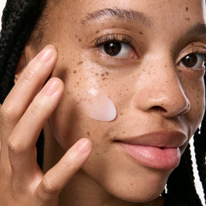 Model applying Vitamin B, C and E Moisturizer to her face