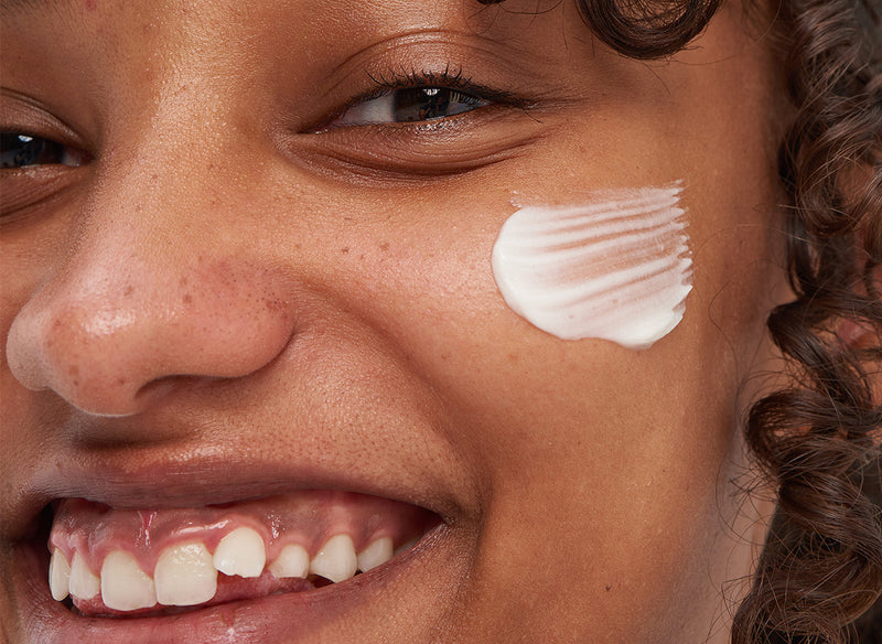 Model with cream on her cheek
