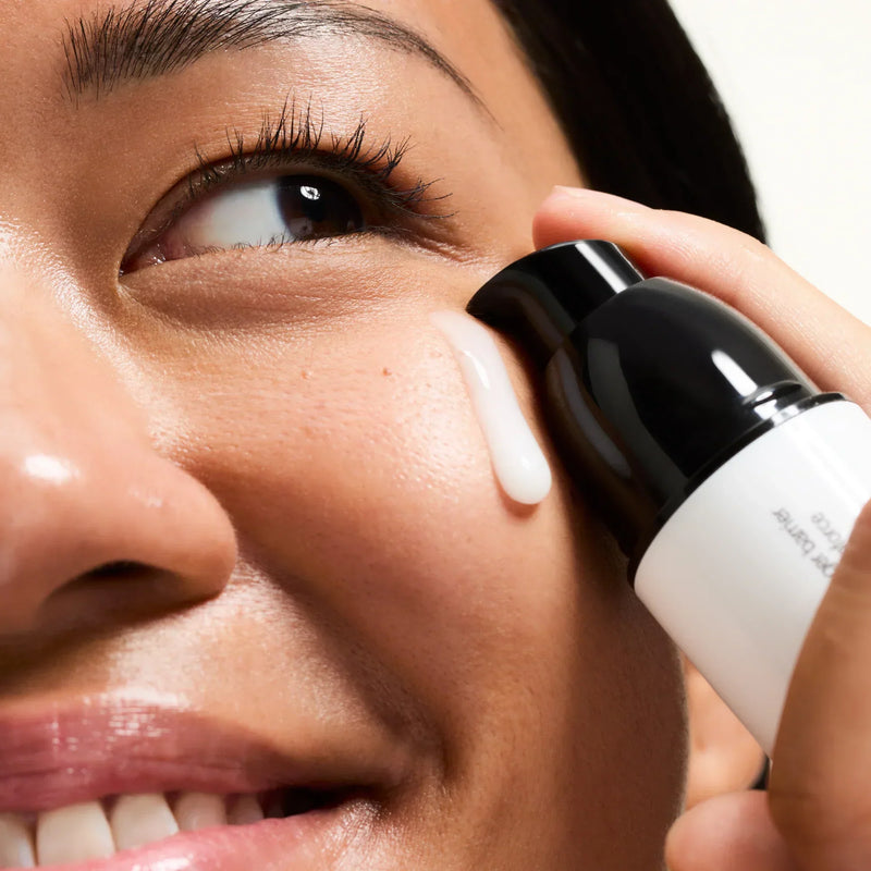 woman applying serum to her face
