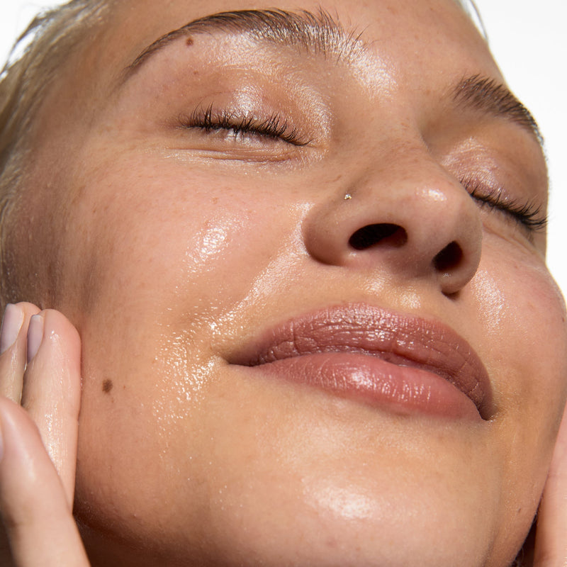 Woman applying serum to her face