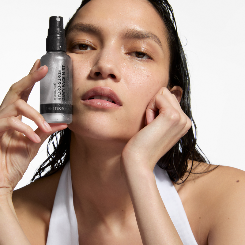 woman holding face mist bottle
