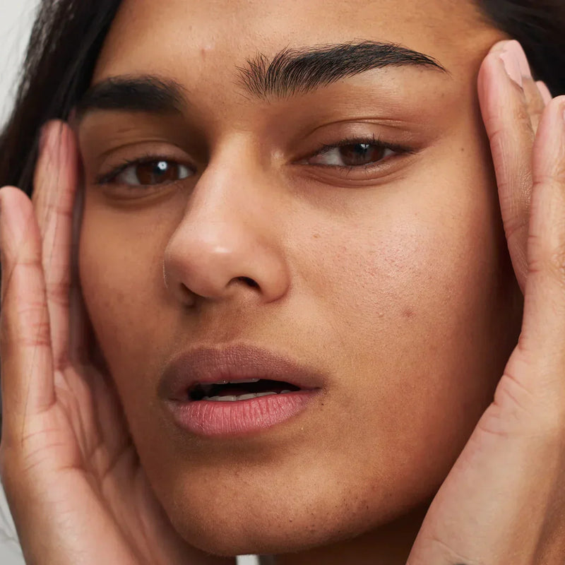 woman holding her face