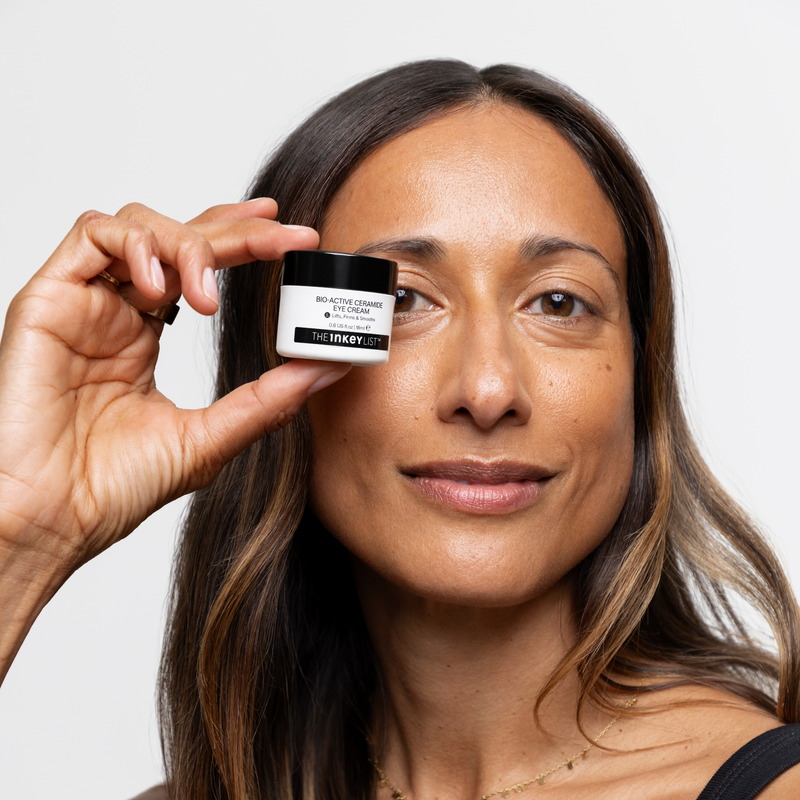 woman holding eye cream near her eye