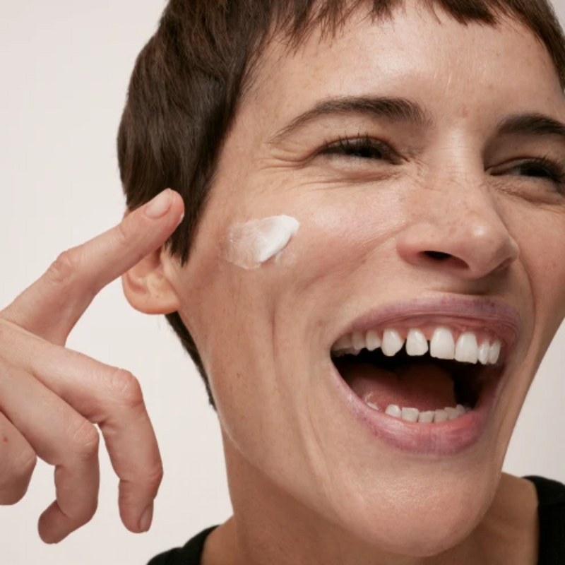 woman laughing with cream on her face