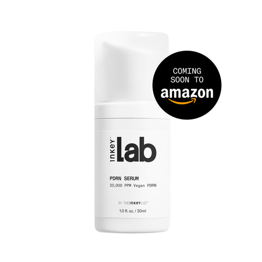 A white cylindrical bottle labeled 'inkey lab' with text reading 'PORN SERUM' and a black circular badge that says 'COMING SOON TO amazon' on a white background.