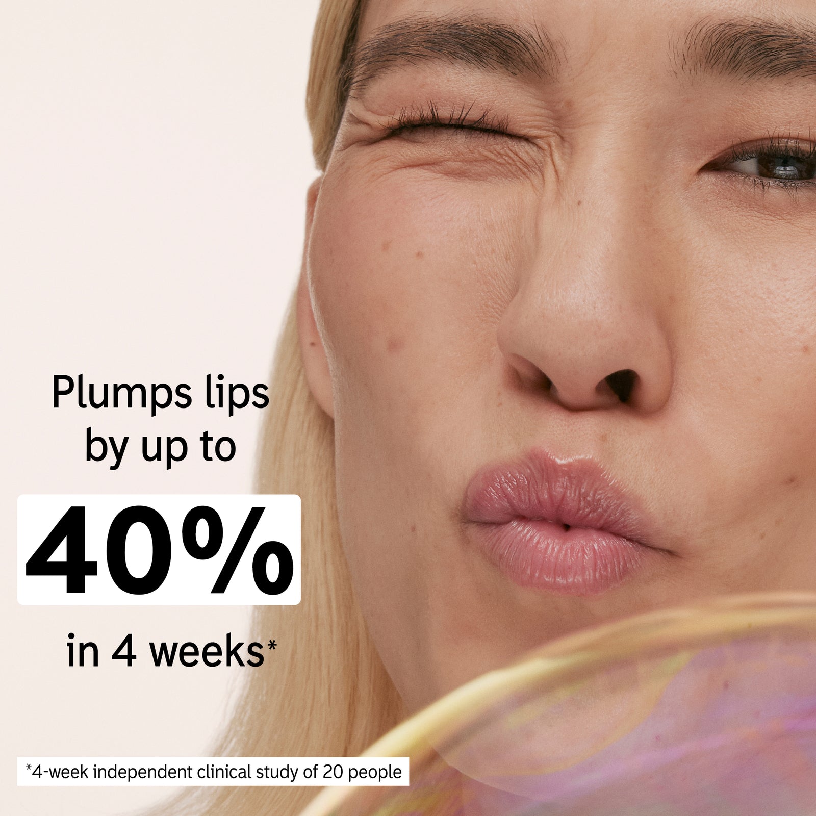 Model holding a tube of Tripeptide Plumping Lip Balm to her face with key claim statistic