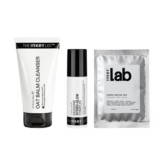 Three skincare products from Inkey arranged side by side on a white background: a white tube labeled Oat Balm Cleanser, a white bottle labeled Exosome Glow, and a silver foil packet labeled Exosome Mask.