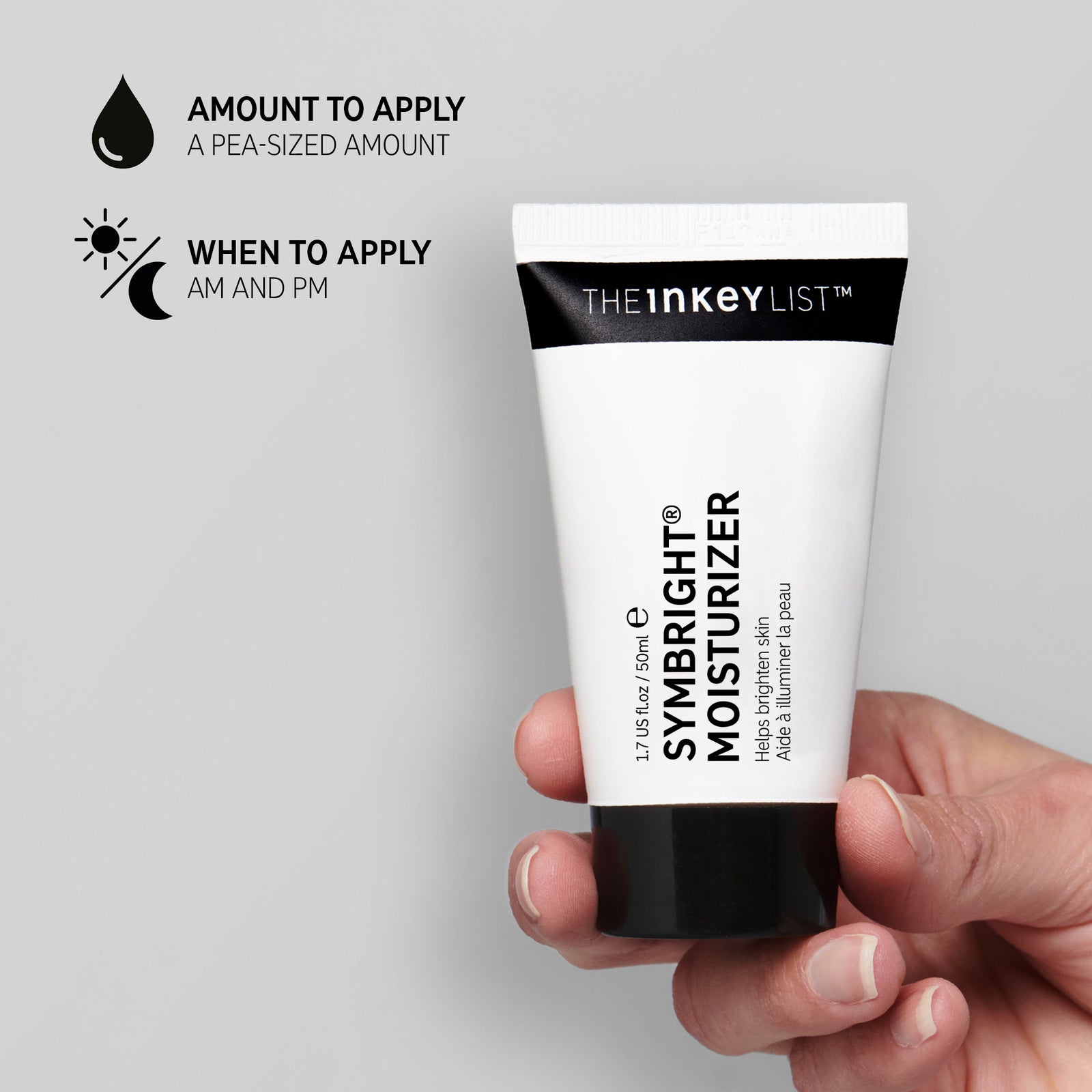 Hand holding Symbright Moisturizer on grey background with black text explaining amount to apply (pea-sized amount) and when to use it (AM and PM)