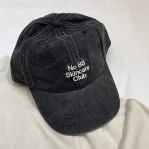 Black cap with 'No BS Skincare Club' text on a white background