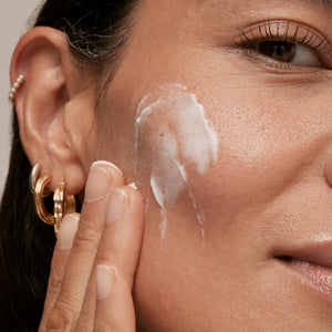 Model applying Bio-Active Ceramide Repairing and Plumping Moisturizer to her face