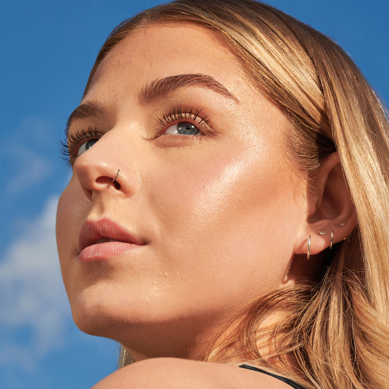 Model looking into the sun against blue sky