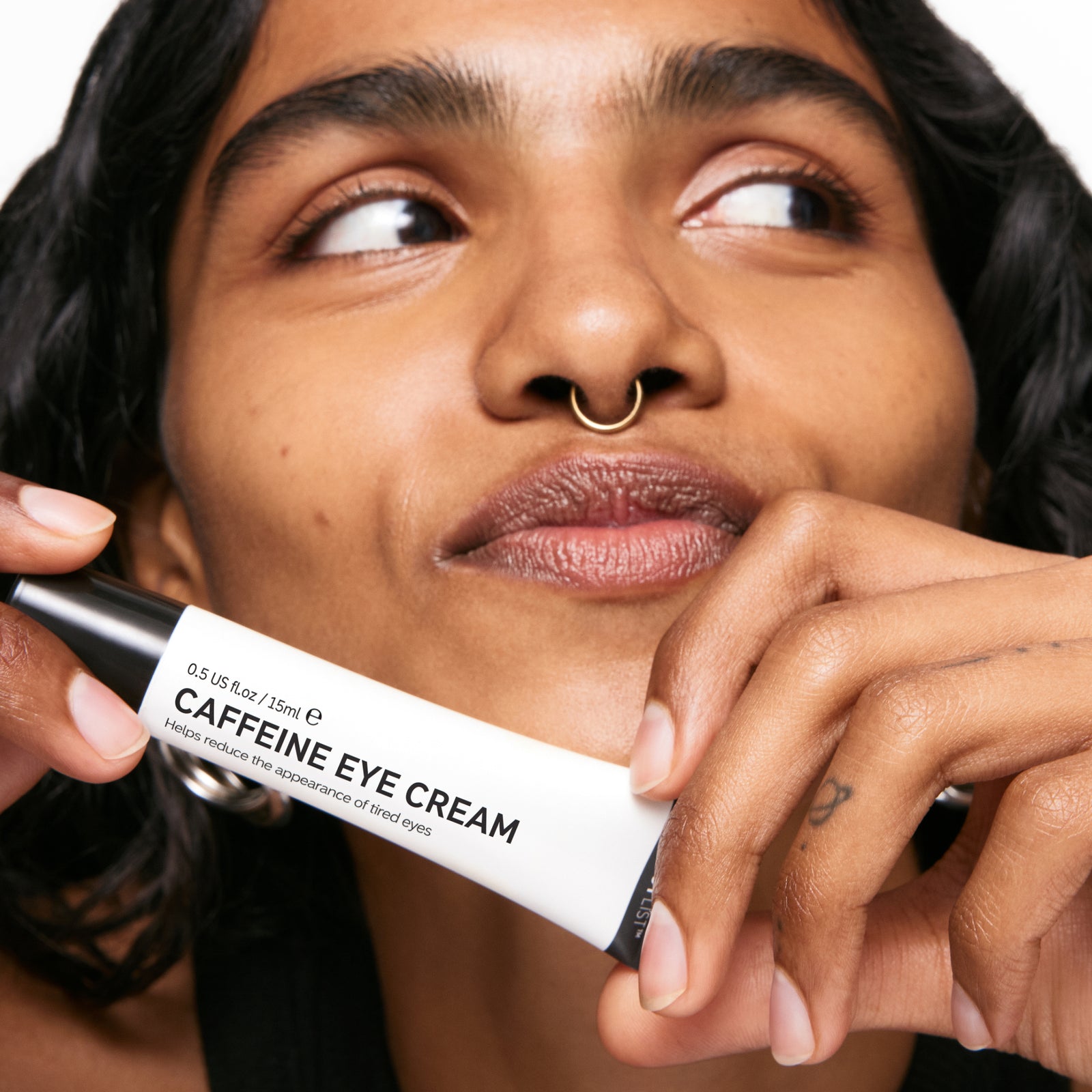 Model holding Caffeine Eye Cream