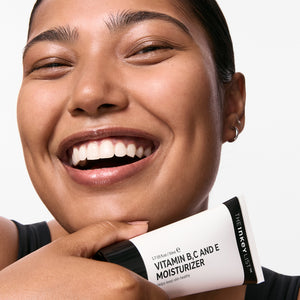 Model holding a bottle of Vitamin B, C and E Moisturizer