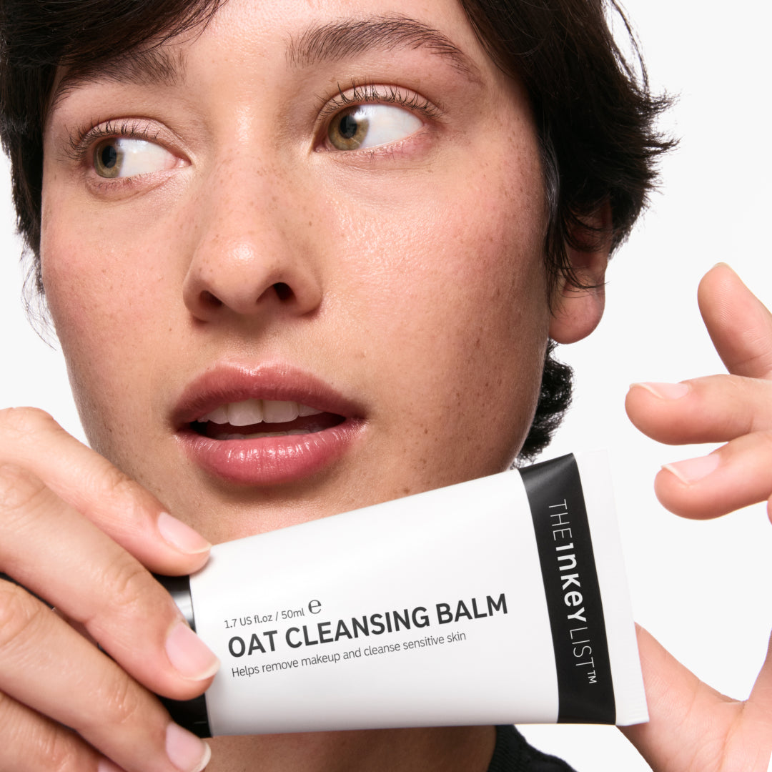 Model holding a bottle of Oat Cleansing Balm 50ml