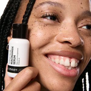 Model holding a bottle of Niacinamide Serum
