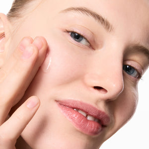 Model applying Niacinamide Serum to her face