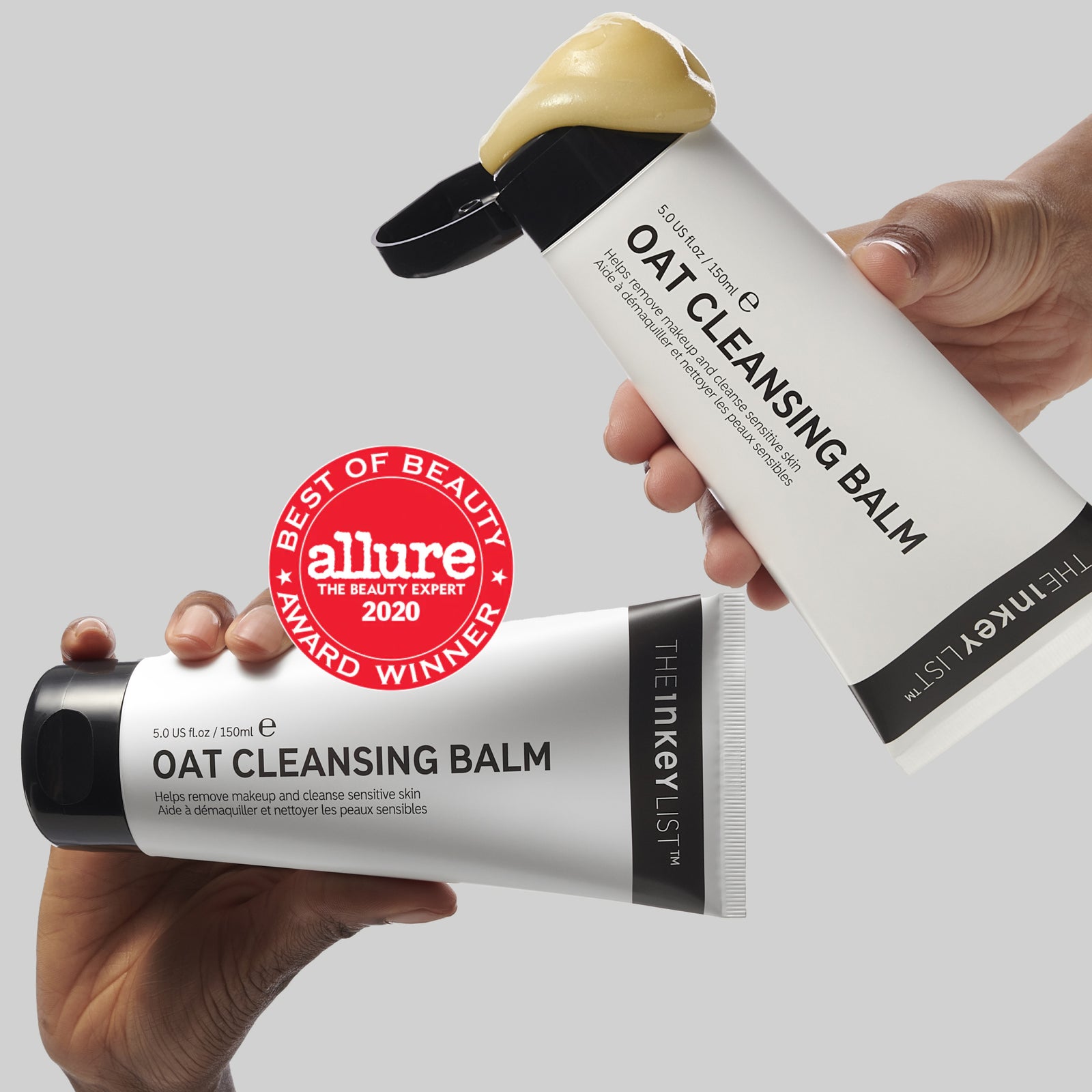 Hands holding Oat Cleansing Balm with awards
