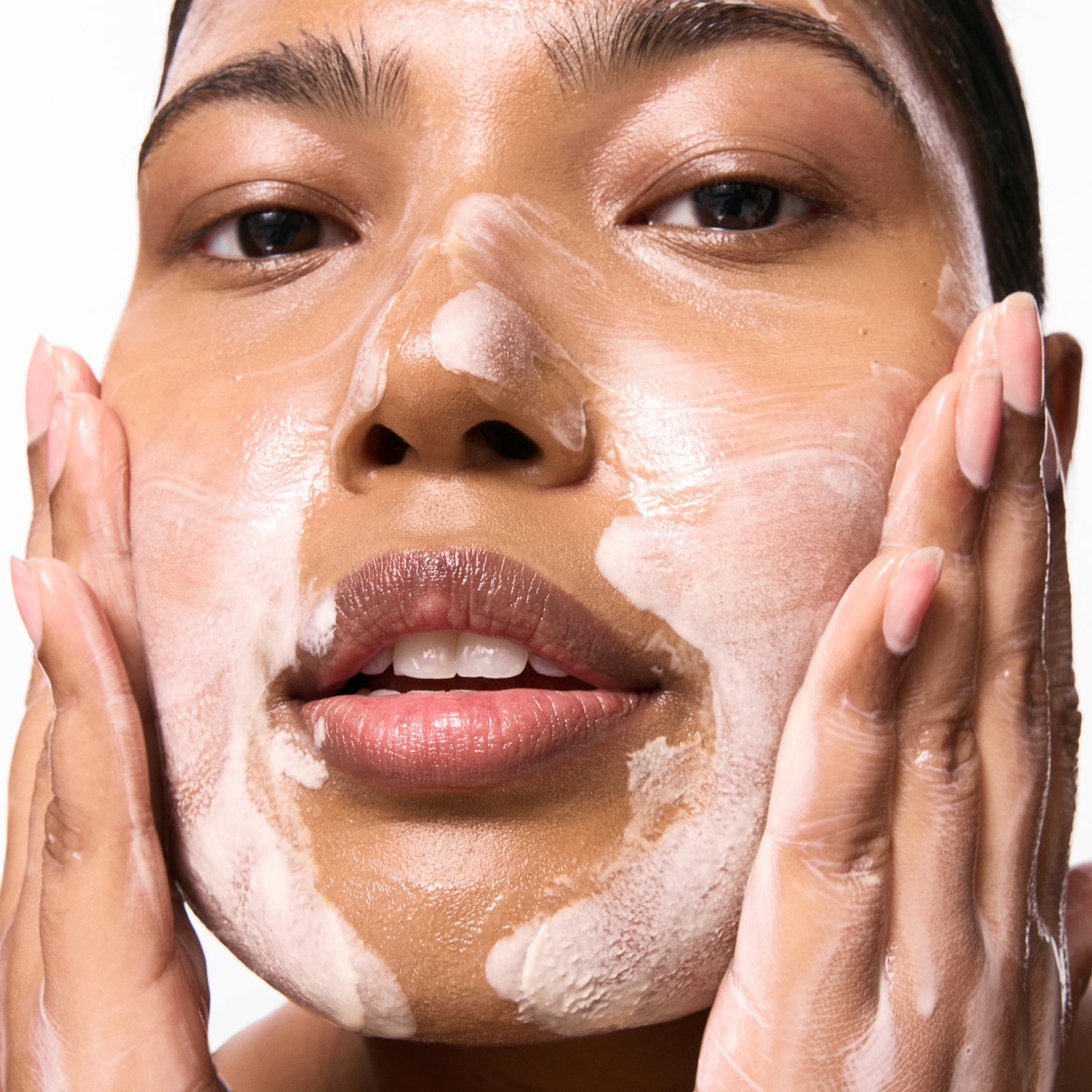 Model cleansing her face with Oat Cleansing Balm