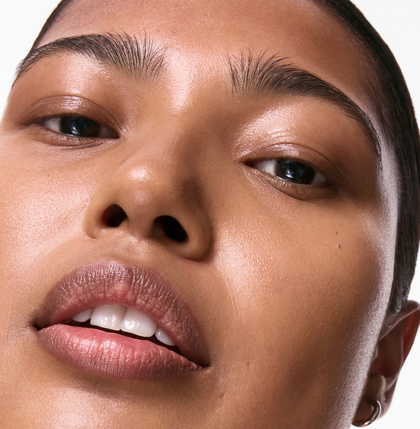 Primer plano del rostro de una persona con un fondo neutro.