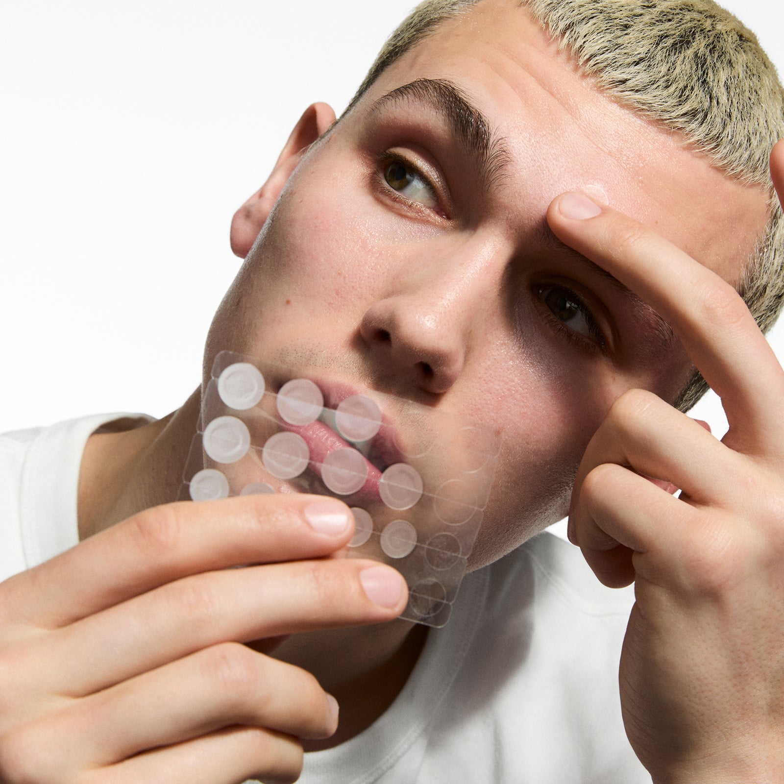Person holding Hydrocolloid Invisible Pimple Patches  against a white background.
