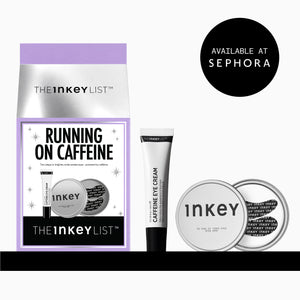 The Inkey List 'Running on Caffeine' eye cream set, featuring a purple and silver pouch, a black and white tube of caffeine eye cream, and two round silver compacts, shown on a white background with a black 'Available at Sephora' badge.
