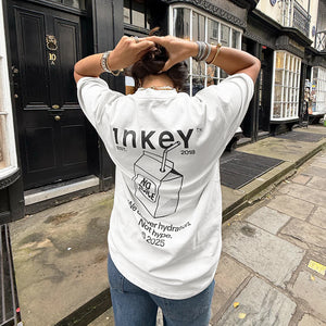 Person wearing a white t-shirt with 'Inkey' branding on a street.
