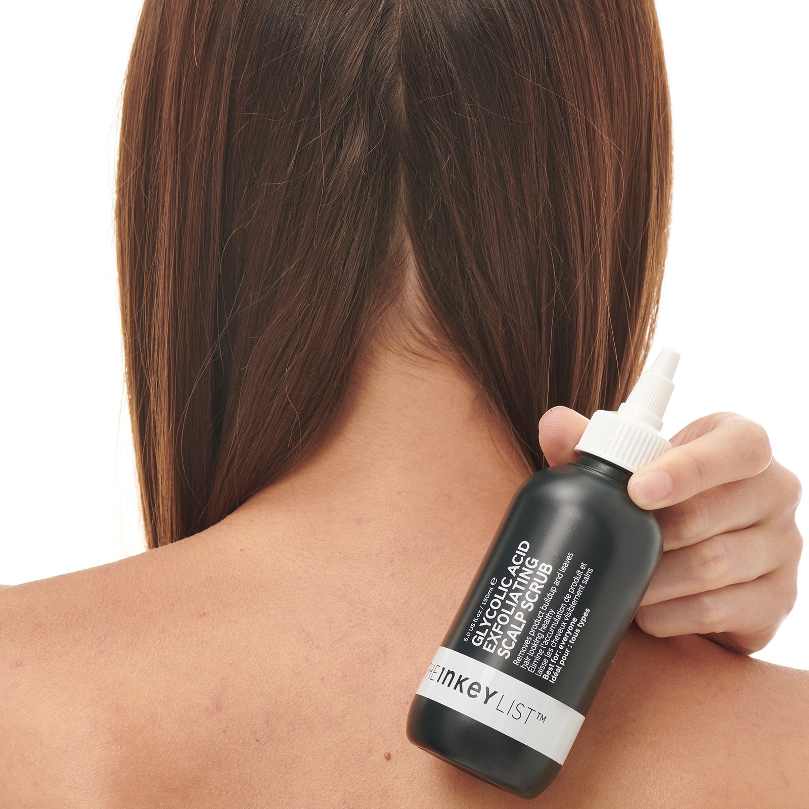 Glycolic Acid Exfoliating Scalp Scrub bottle being held by a model
